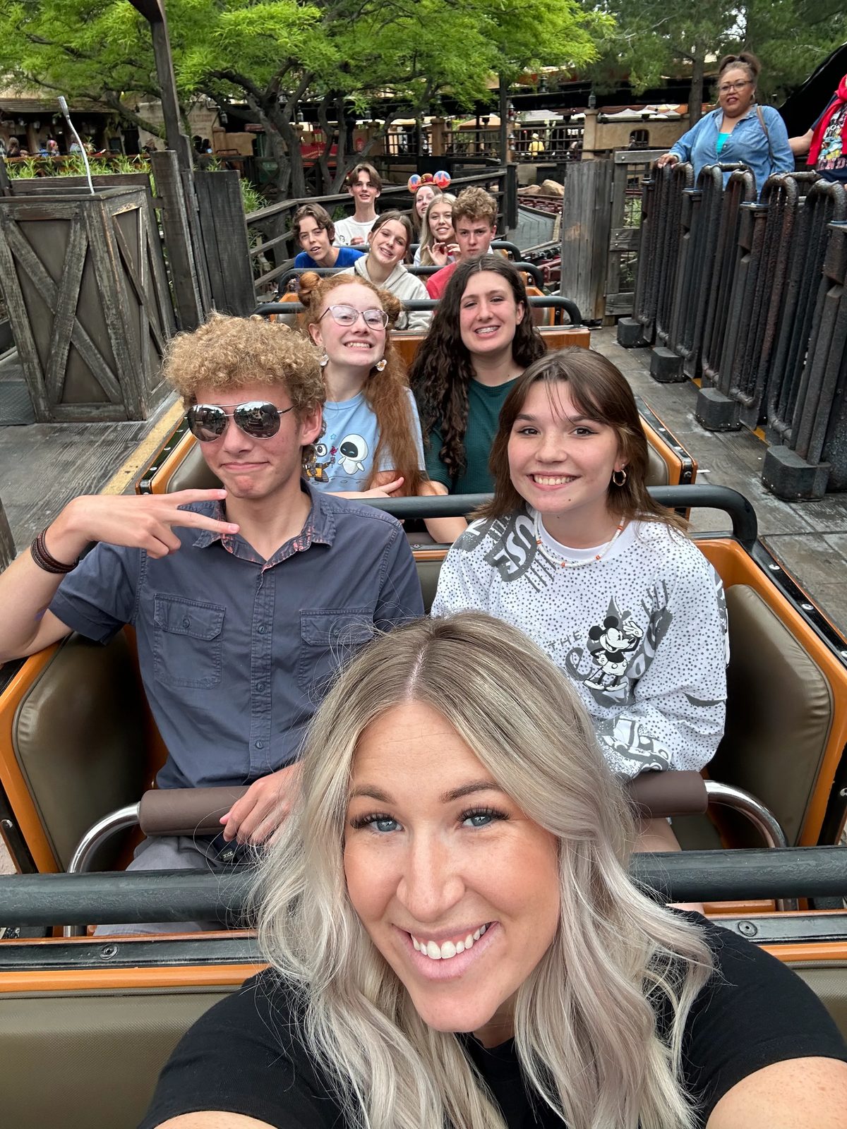 Aspire Young Artists and a mentor filling the rows of a mine train coaster
