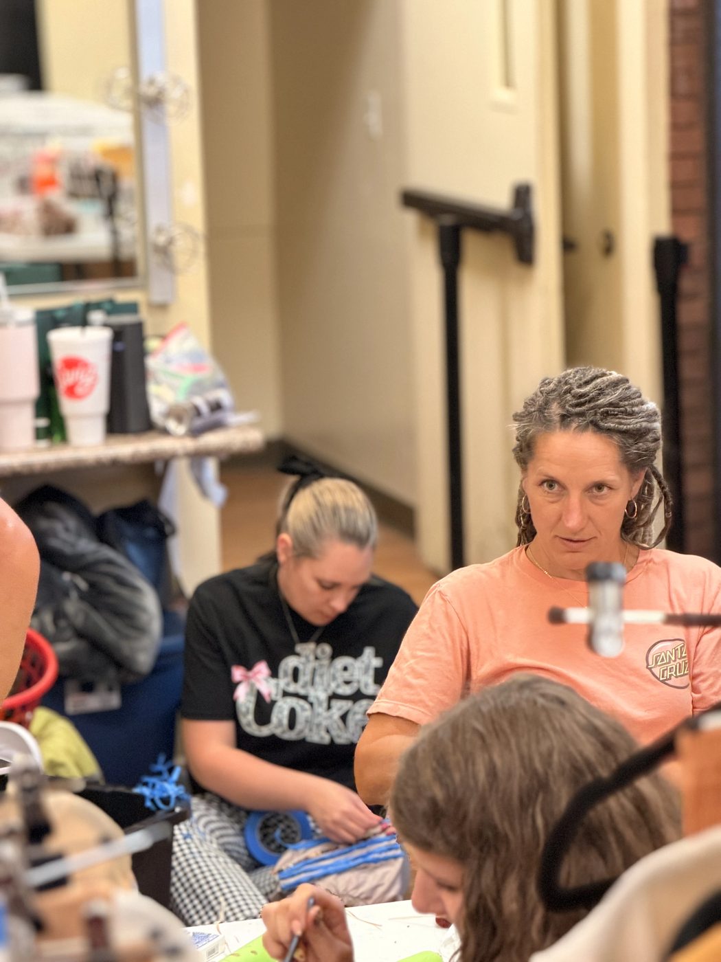 Volunteers work yarn for wigs and masks in the dressing room