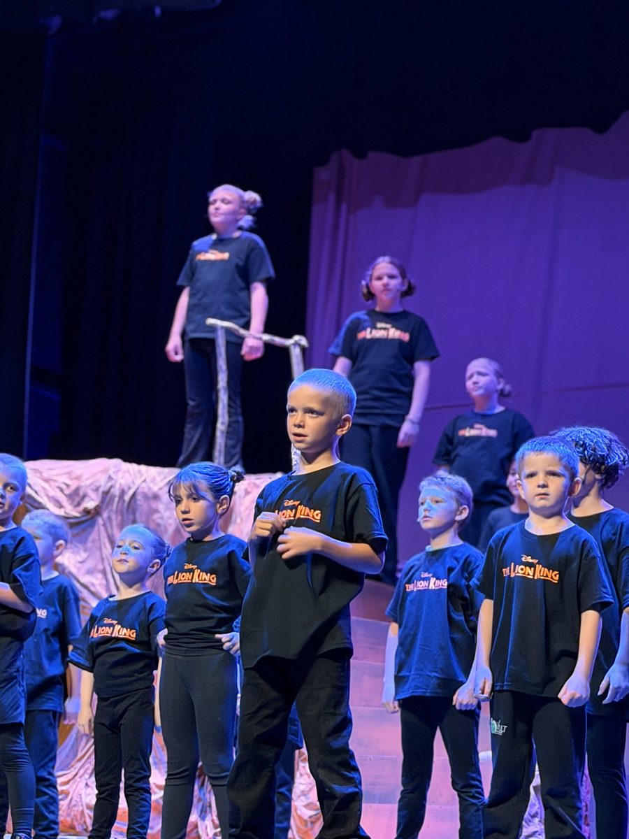 Young Artists performing a number in blue light