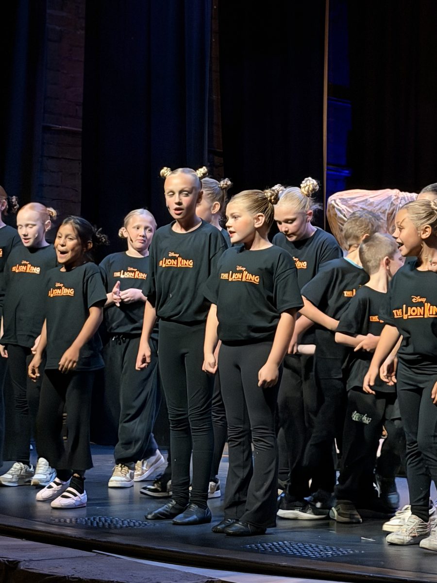 The ensemble performing under stage lights