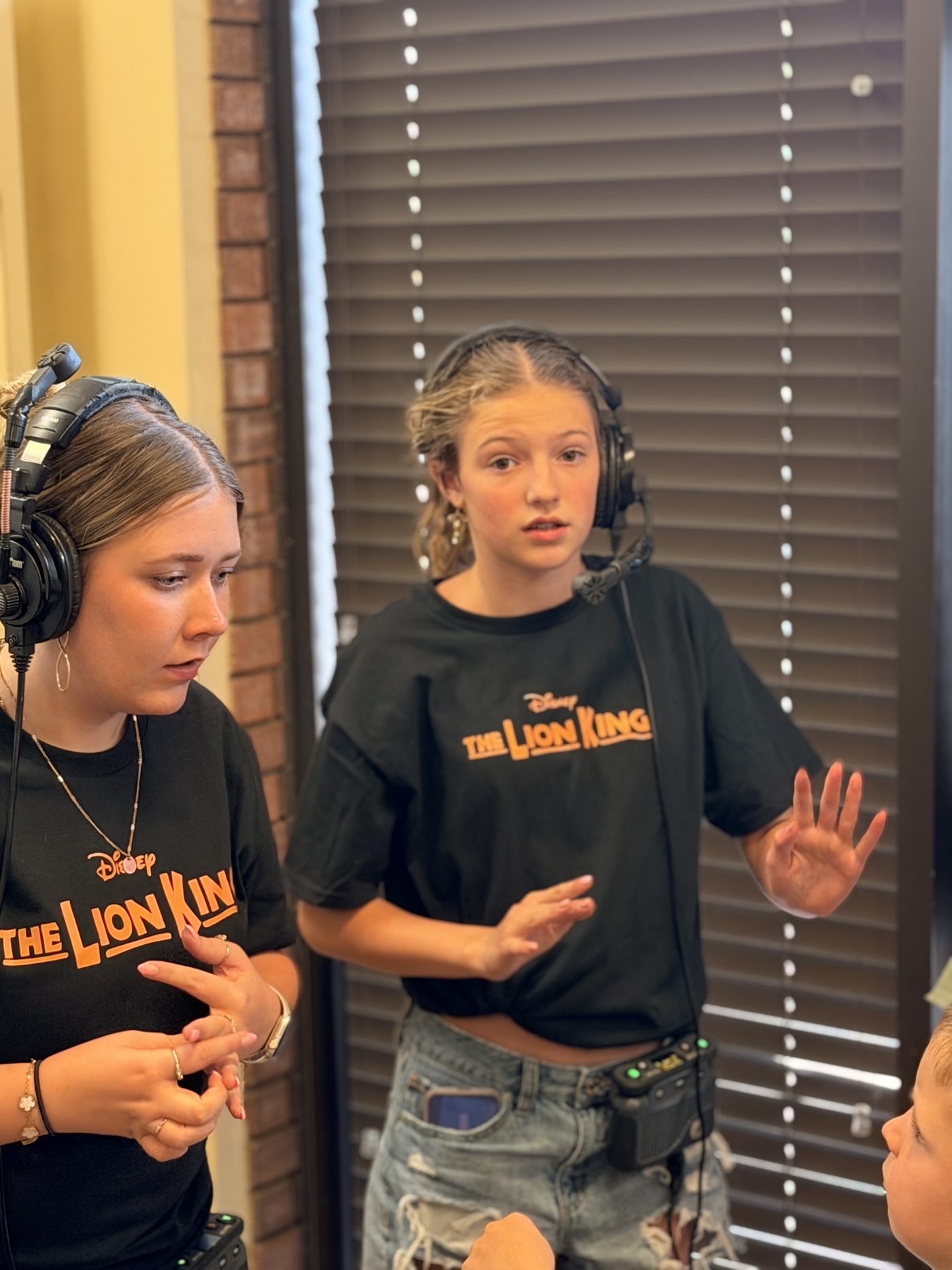 Two teen stage managers on headset backstage during the camp performance
