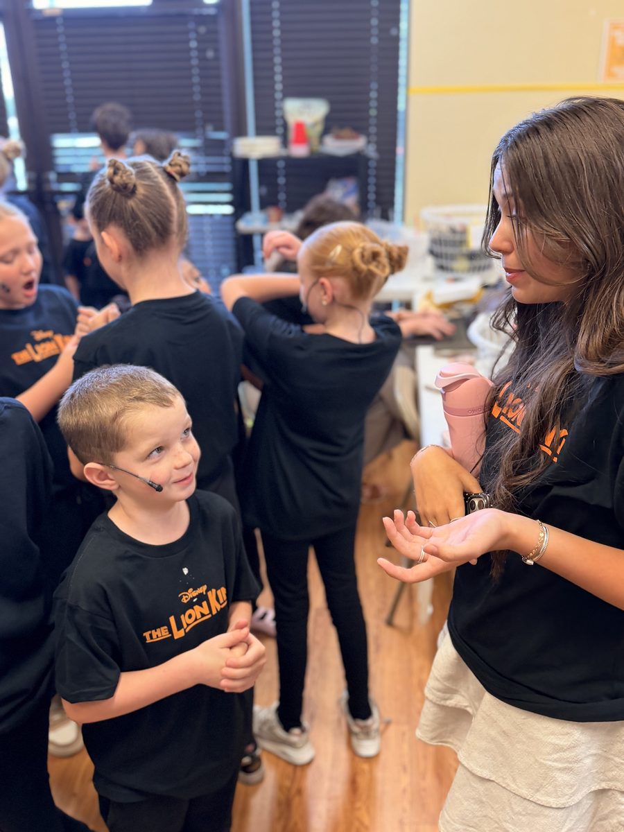 A teen leader coaching a Young Artist backstage