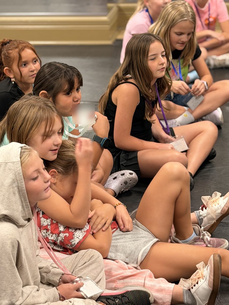 Campers sitting together on the floor listening to instructions