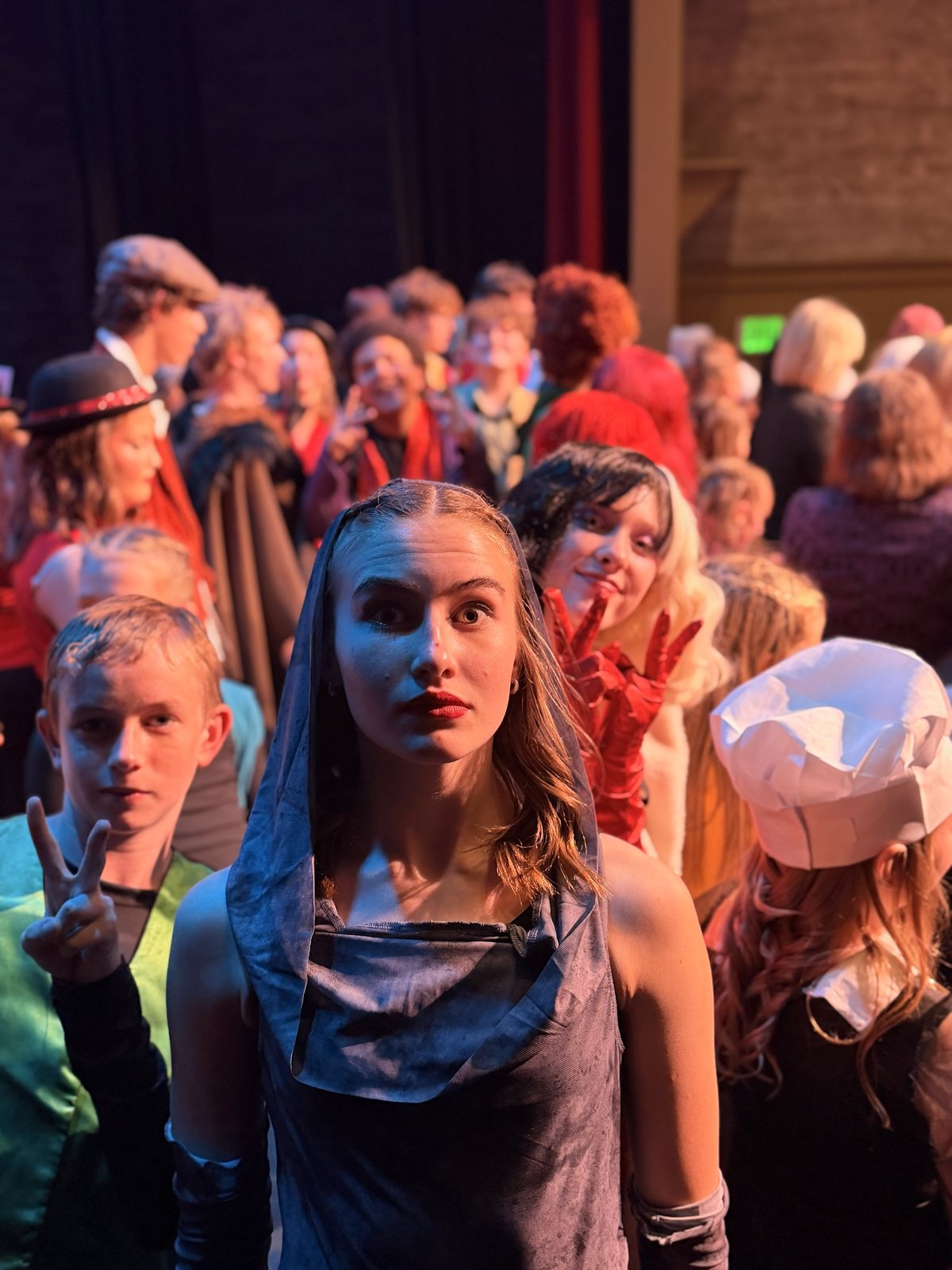 A Villains Night performer waiting in the wings in costume and makeup with the company behind