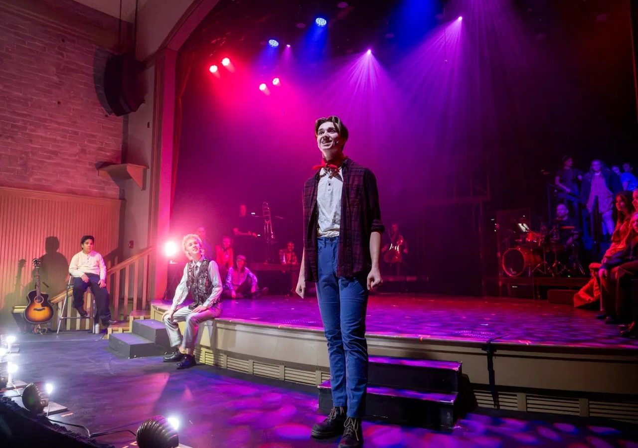 A Young Artist performing a solo in the spotlight during an Encore production